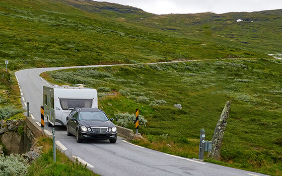 Wohnwagengespann fährt über eine enge Passstrasse