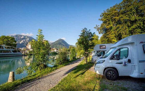 Un camper in sosta in un parcheggio lungo il fiume