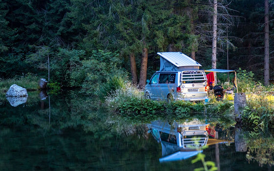 Camper Van steht mitten in der Natur