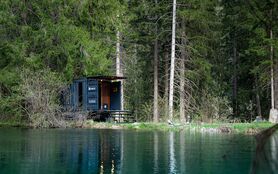 There is a sauna next to the small lake.