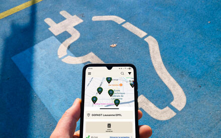 Main tenant un smartphone avec l'application eCharge ouverte.