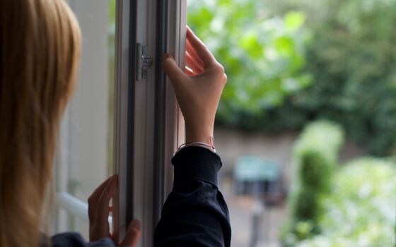 Frau kontrolliert, ob die Dichtungen in Ihrem Fenster noch intakt sind.