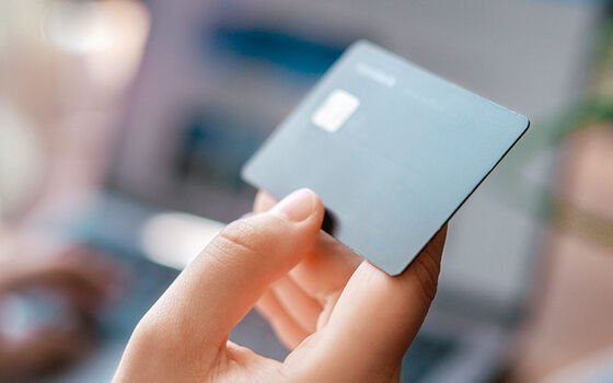 Frauenhand hält eine schwarze Kreditkarte