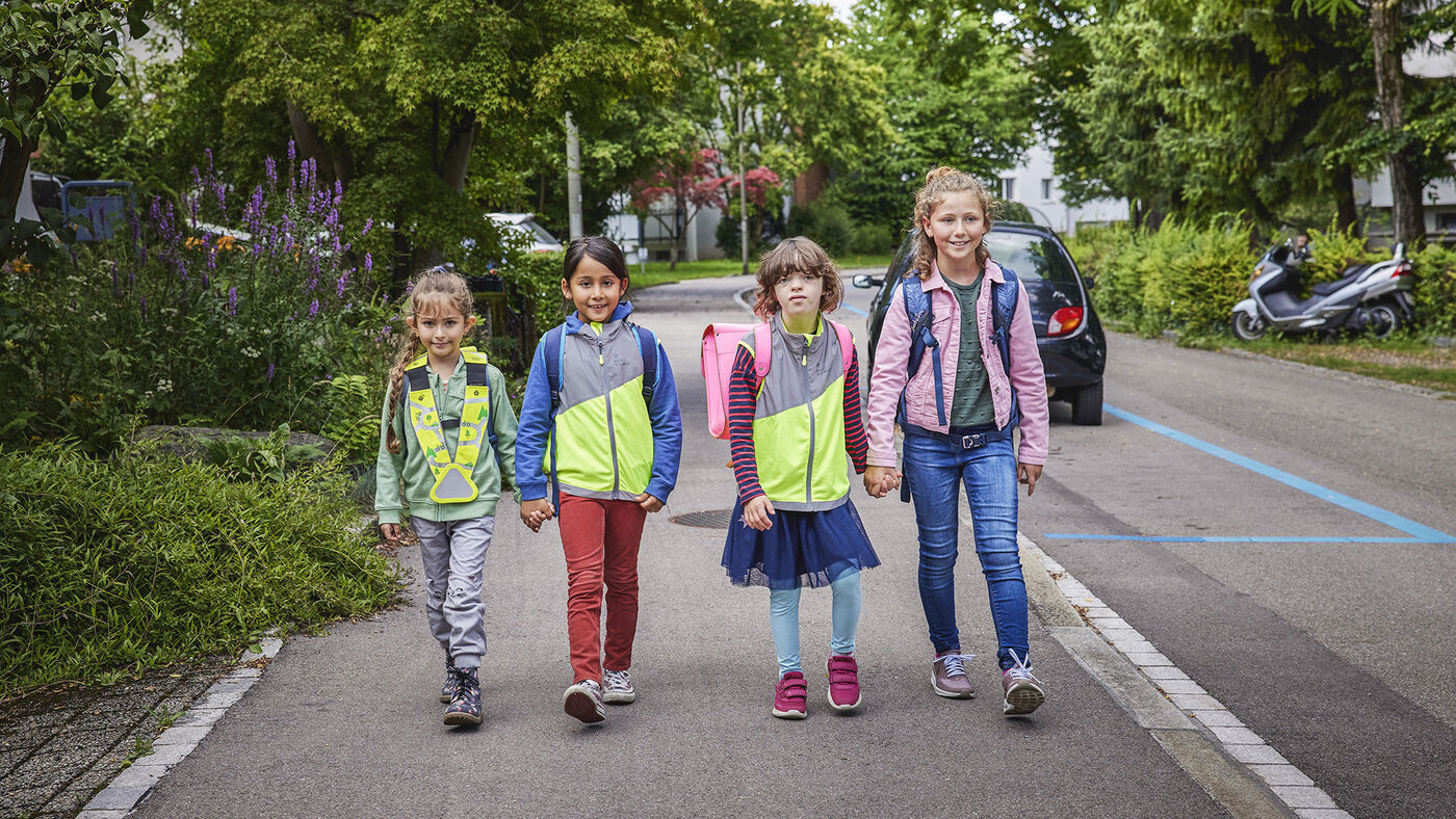 Zwei Kinder auf dem schulweg mit reflektierender Schutzweste